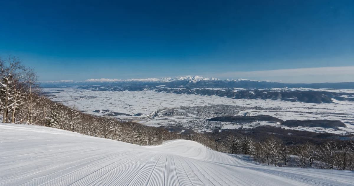 富良野冬季空雪道、山谷與雪山的寫實照片